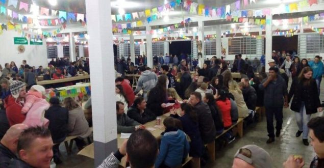 Fiéis participando dos festejos na noite das 'Barraquinhas', no salão da Paróquia São Pedro, em Mallet.