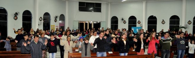 Fiéis leigos, e líderes da paróquia Czestochowa de mãos dadas na Oração do Pai-Nosso.