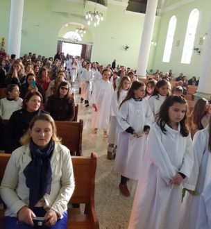 Familiares acompanhado os filhos (as) em procissão na missa.