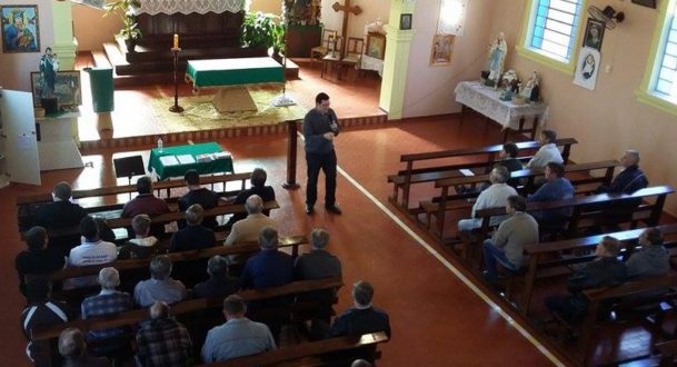 Seminarista João Henrique falando aos 'Homens do Terço', no interior da Capela do Bromado.